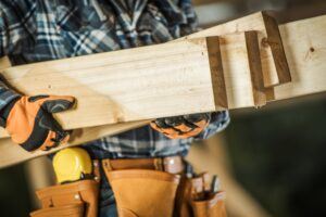 Contractor carrying planks