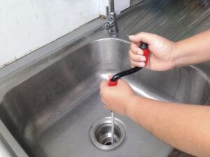 Plumber unblocking a drain